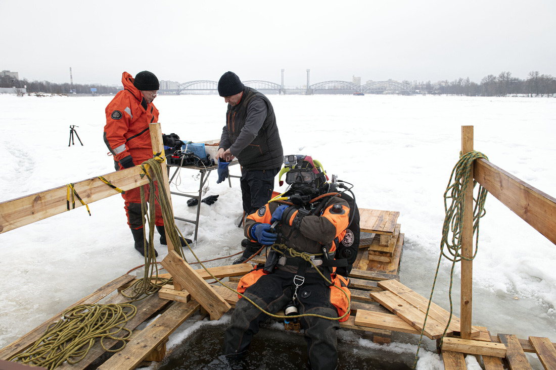 Подготовка водолаза к погружению для обследования дна Невы вблизи Октябрьской набережной Санкт-Петербурга